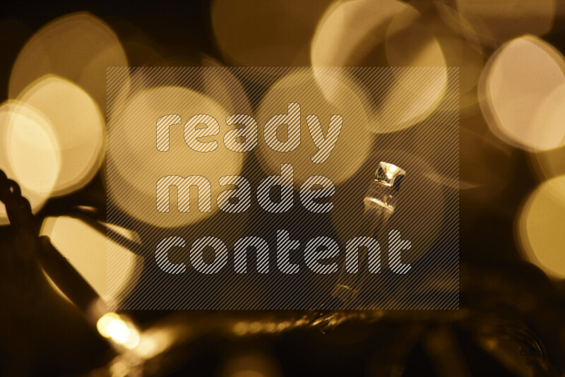 Light bulbs glowing against backdrop of golden bokeh