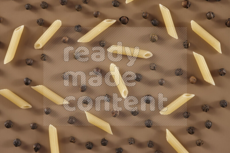 معكرونة مع مكونات متنوعة من الطماطم والثوم والبصل والفلفل الأحمر والفلفل الأسود والفلفل الأبيض وأوراق الغار وإكليل الجبل والهيل على خلفية بيج