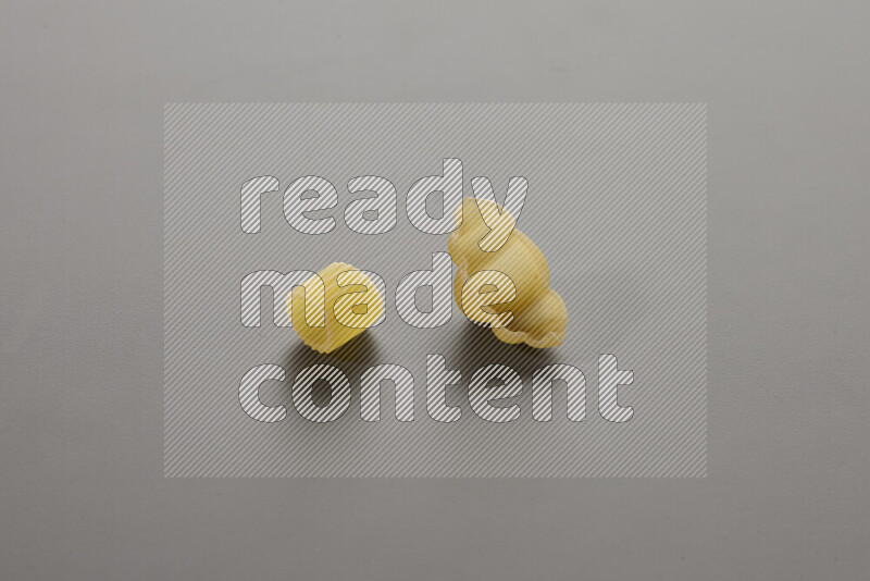 Big rings pasta with other types of pasta on grey background