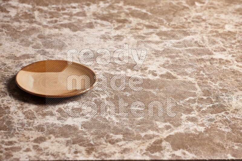A multicolored pottery plate on beige marble background