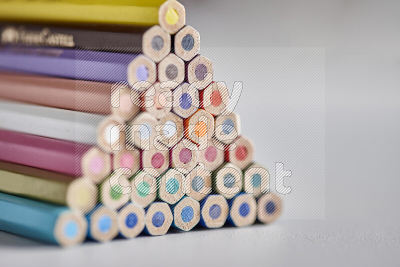 A close-up of the tips of colored pencils arranged in a bundle on white background