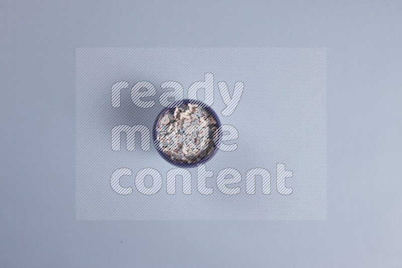 Multicolored pottery bowls full of colored buttons on blue background