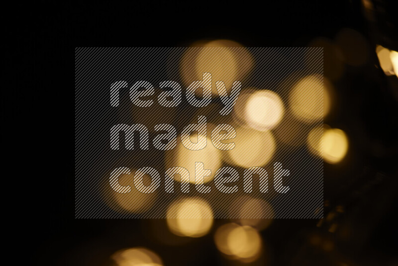 Light bulbs glowing against backdrop of golden bokeh