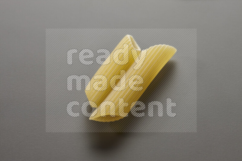 Penne pasta on grey background