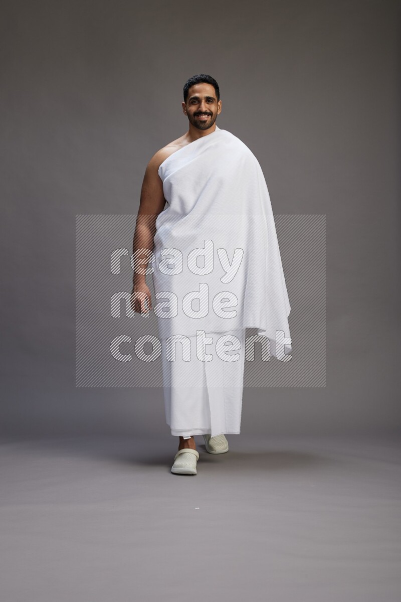 A man wearing Ehram Standing Interacting with the camera on gray background