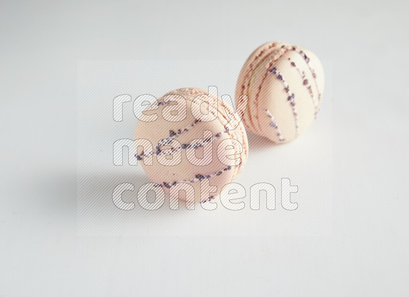 45º Shot of two pink orange blossom macarons on white background