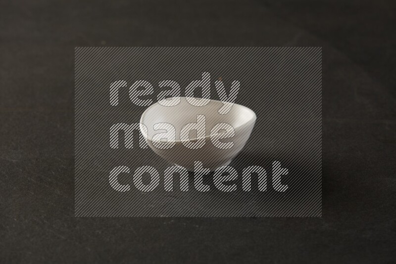 white ceramic round sauce bowl on grey textured countertop