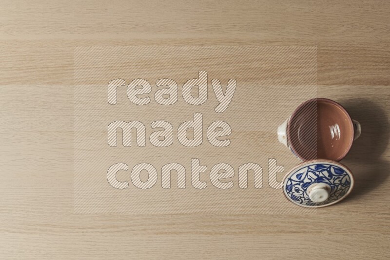 A multicolored pottery pot on light wooden background