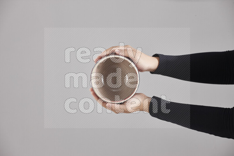 A woman in black abaya holding different pottery essentials in different positions