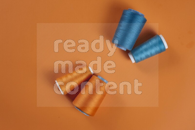 A blue collection of sewing and tailoring tools arranged on a orange background