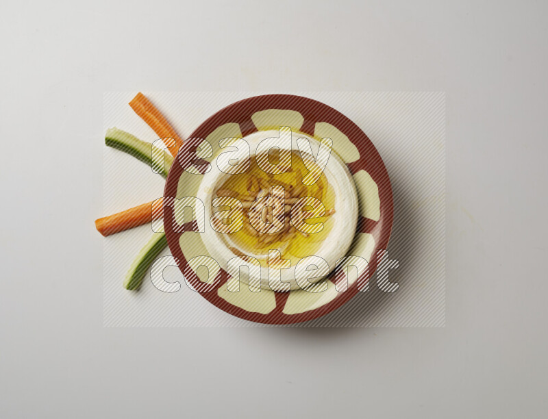 Lebnah garnished with pine nuts in a traditional plate on a white background