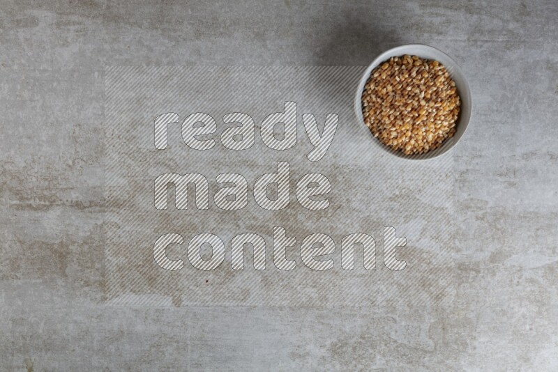 corn kernel in a gray ceramic bowl on a grey textured countertop
