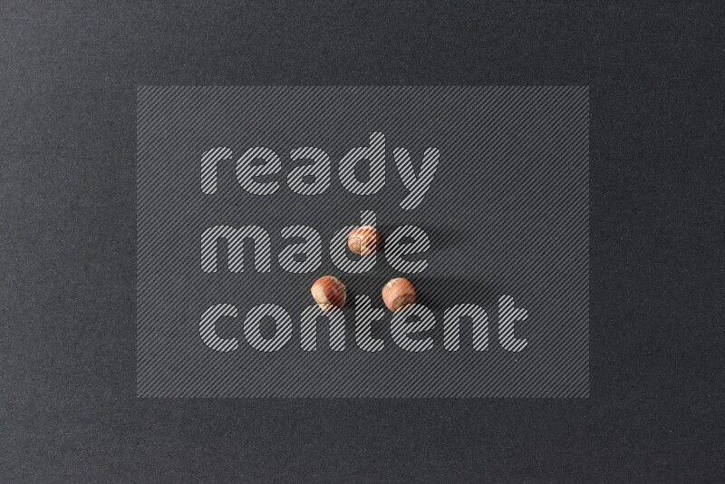 3 hazelnuts on a black background in different angles