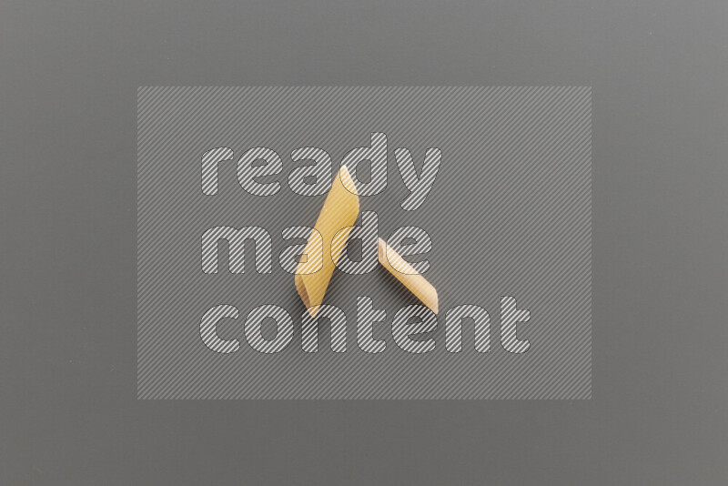 Penne pasta with other types of pasta on grey background
