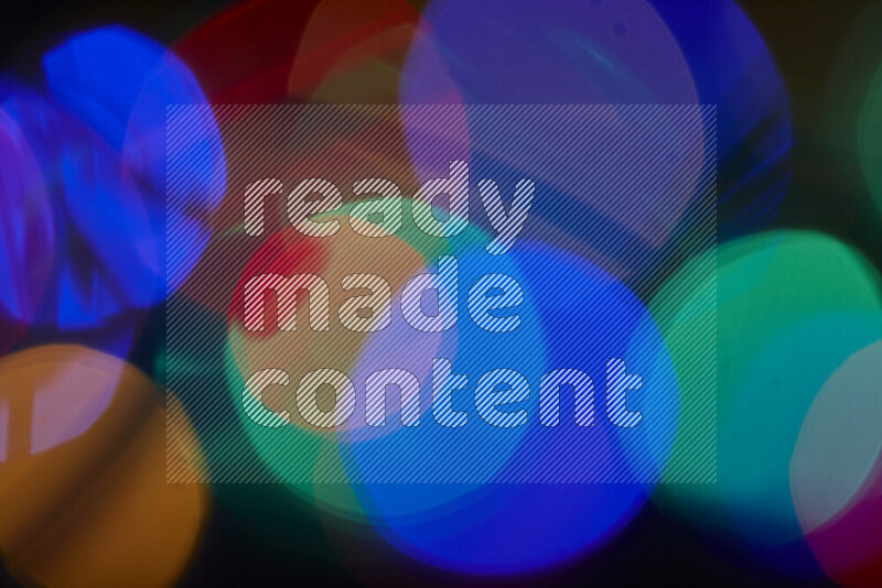 Light bulbs glowing against backdrop of multicolord bokeh