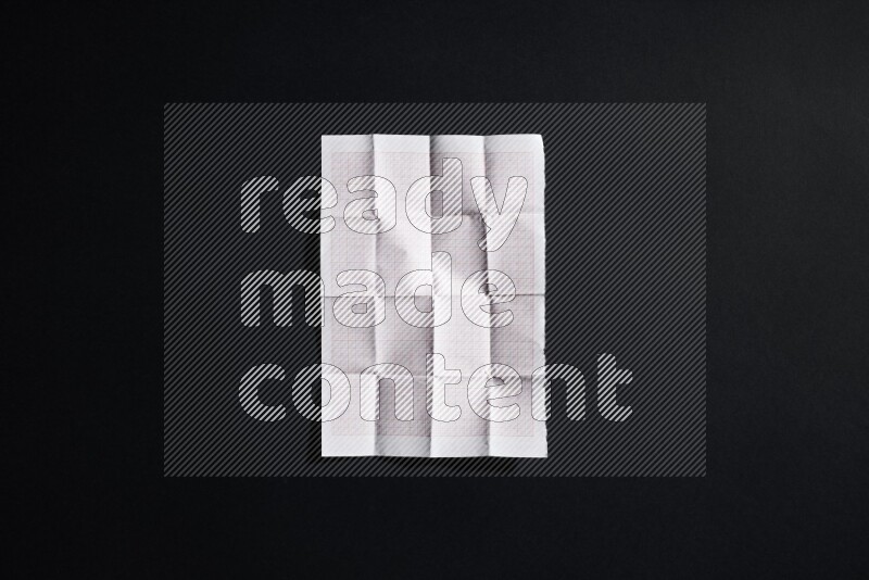 Folded notebook sheet on black background