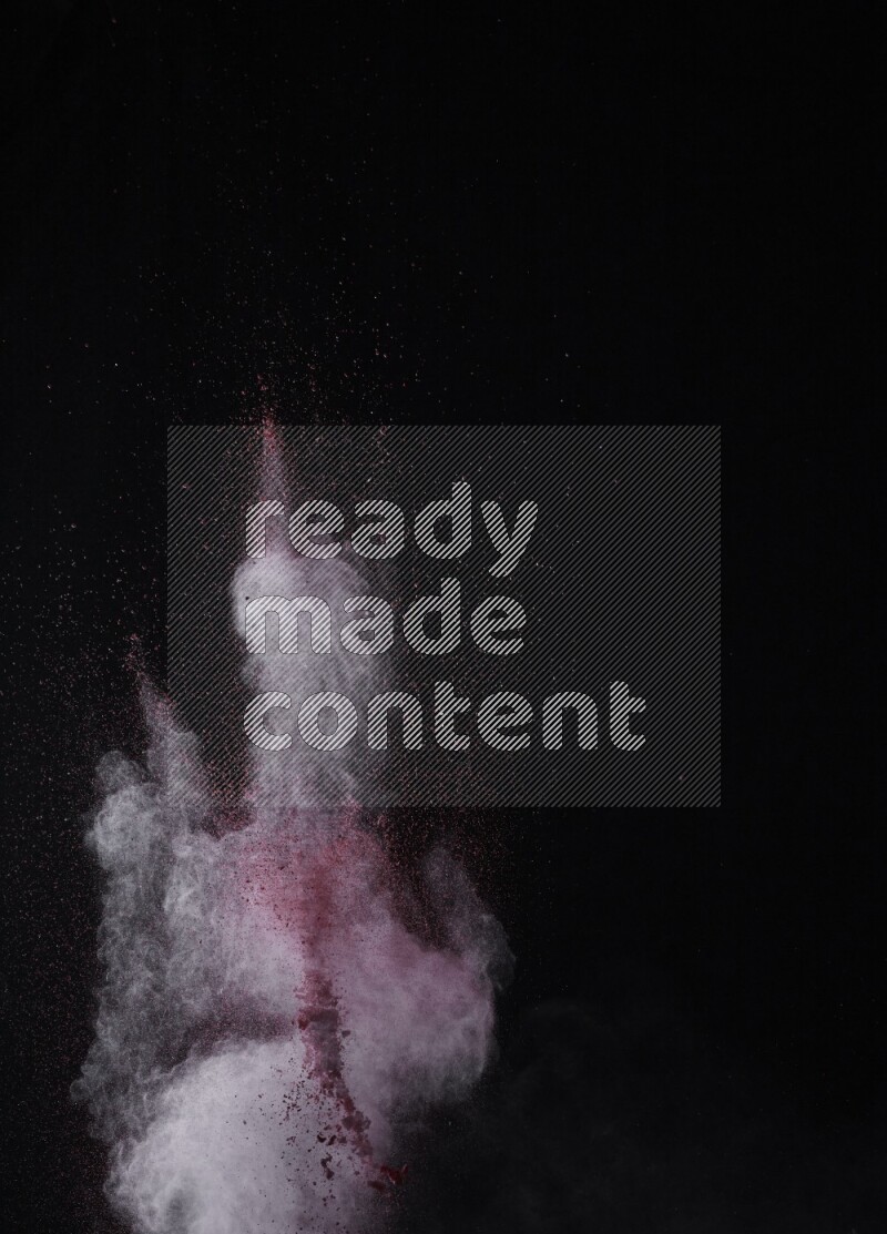A side view of red powder explosion on black background