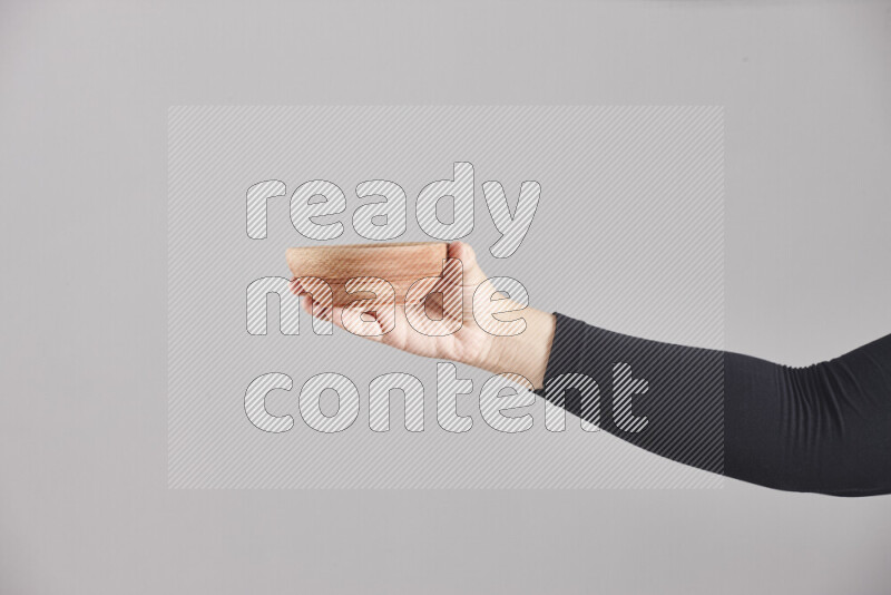 امرأة ترتدي عباءة سوداء تحمل أدوات خشبية مختلفة في أوضاع متعددة