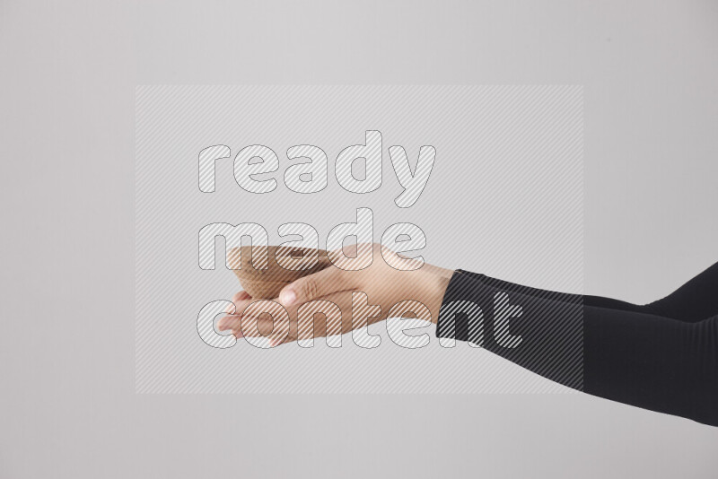 A woman in black abaya holding different wooden essentials in different positions