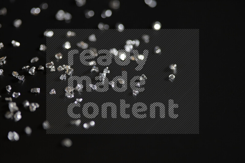 قطع زجاجية فضية لامعة متناثرة على خلفية سوداء