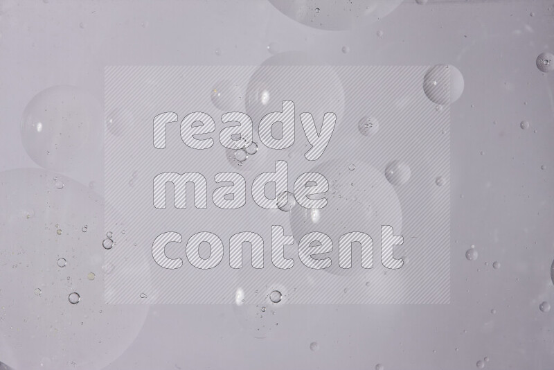 قطرات من الزيت على سطح الماء على خلفية بيضاء