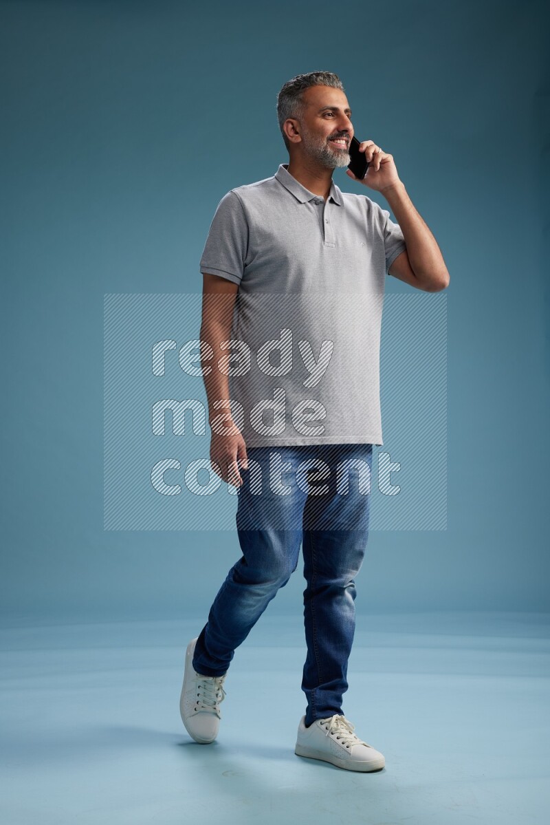 Man Standing talking on phone on blue background