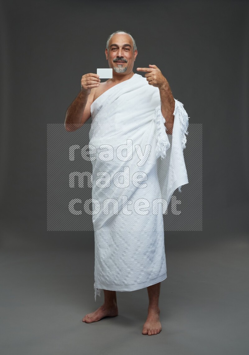 A man wearing Ehram Standing holding ATM card on gray background