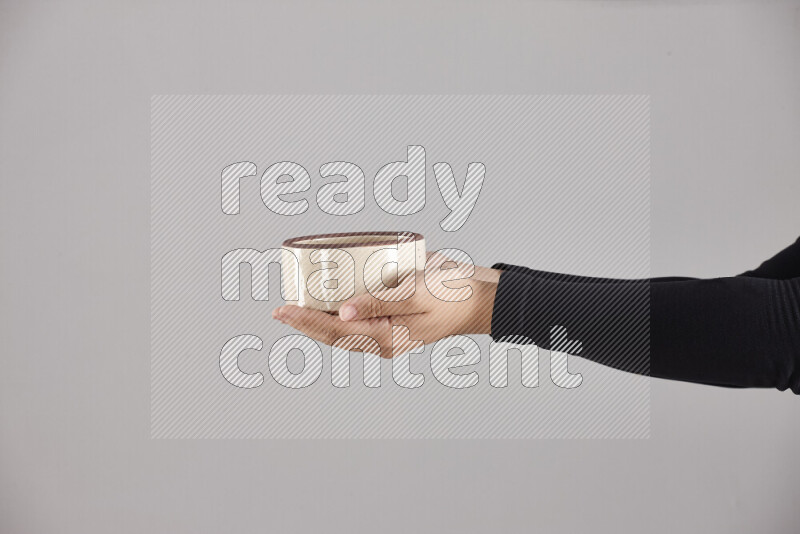 امرأة ترتدي عباءة سوداء تحمل أدوات فخارية مختلفة في أوضاع متعددة