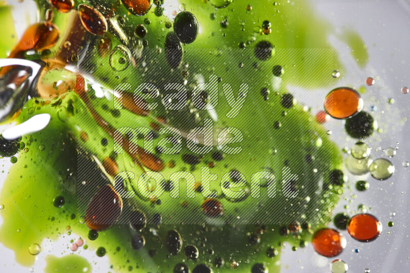 Close-ups of abstract red, blue, yellow and green watercolor drops on oil Surface on white background