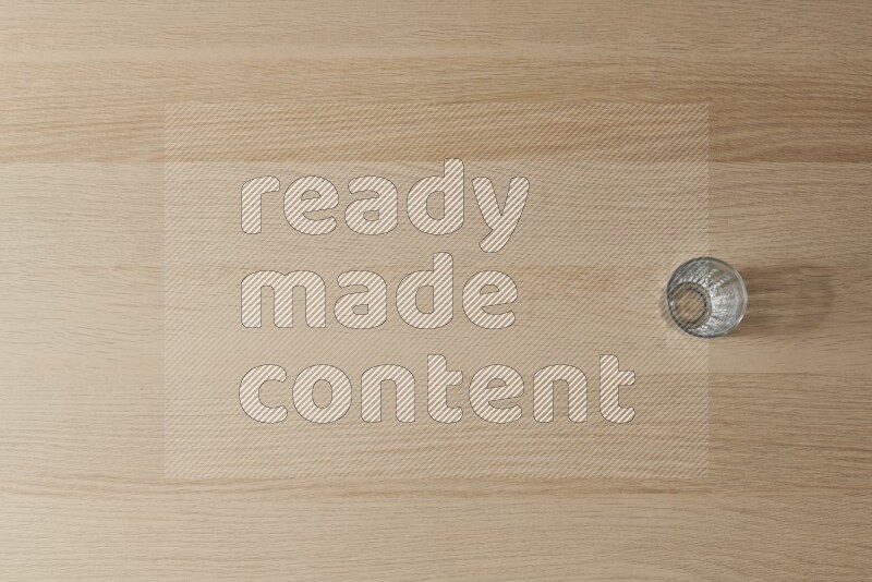 An empty glass cup on light wooden background