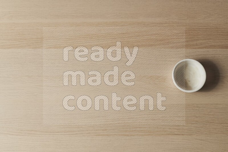 وعاء فخاري أبيض على خلفية خشبية فاتحة