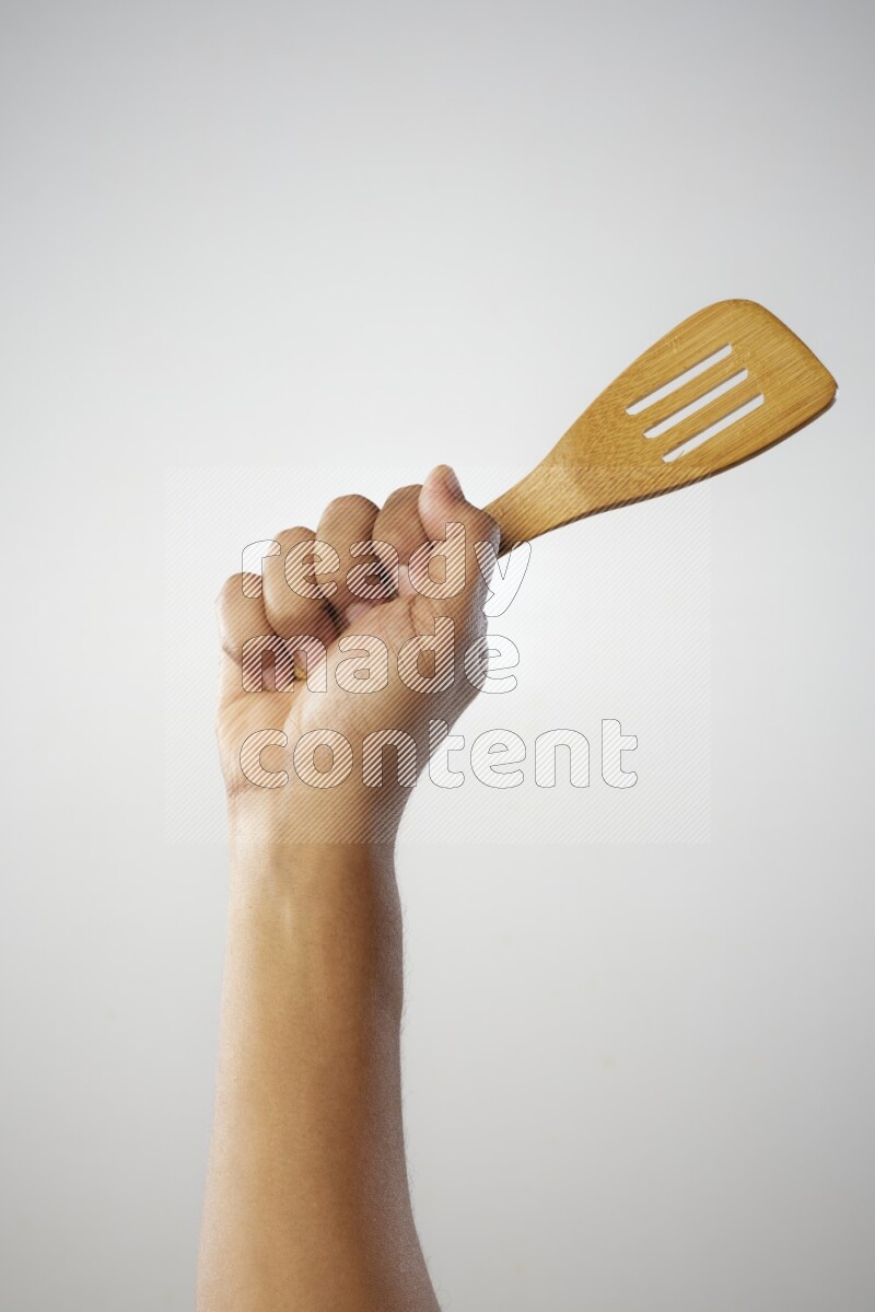 Male Hand Holding Slotted Turner on white background