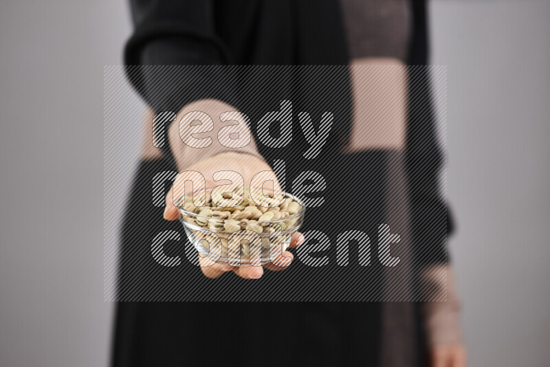 Woman in abaya holding different kinds of legumes in different positions