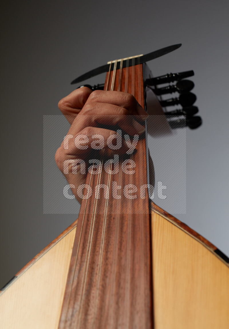 a hand intracting with a wooden brown Oud