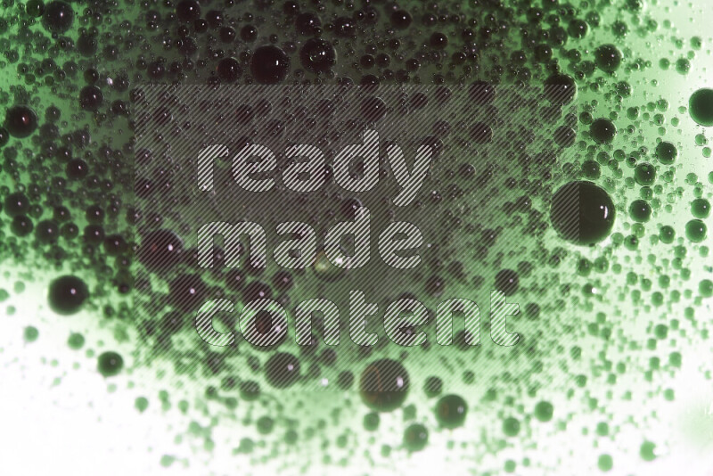 Close-ups of abstract green watercolor drops on oil Surface on white background