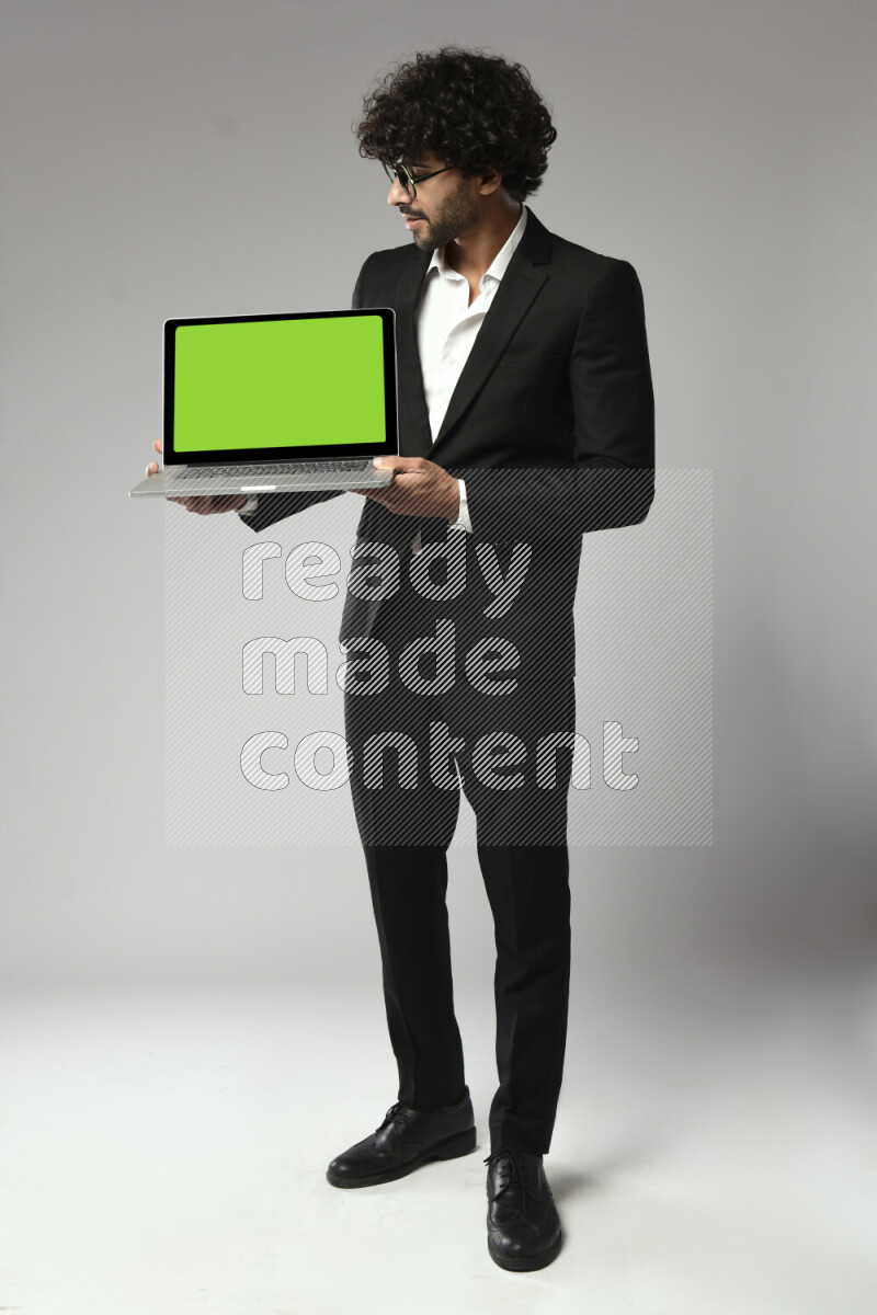 A man wearing formal standing and showing a laptop screen on white background