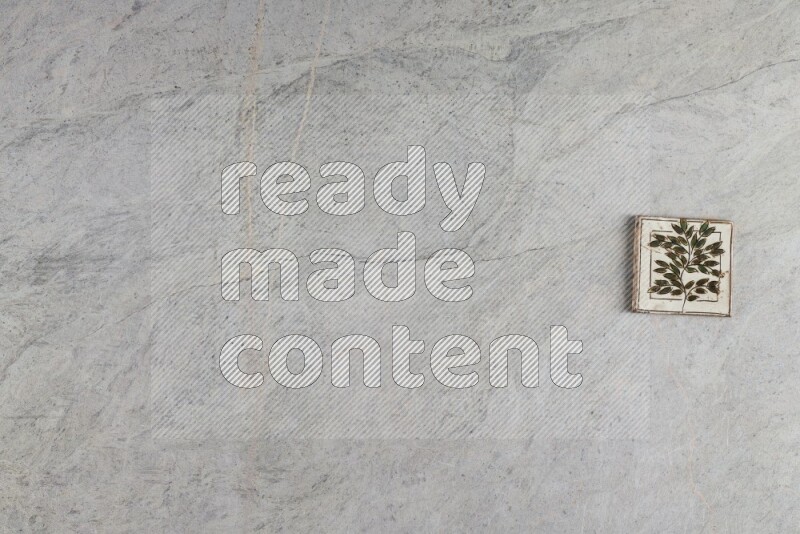 A decorative pottery coaster on grey marble background