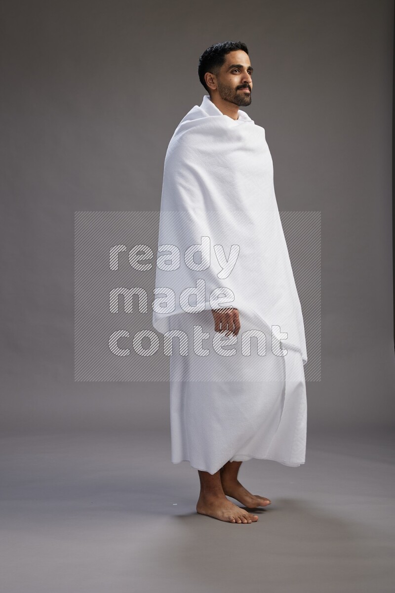 A man wearing Ehram Standing Interacting with the camera on gray background