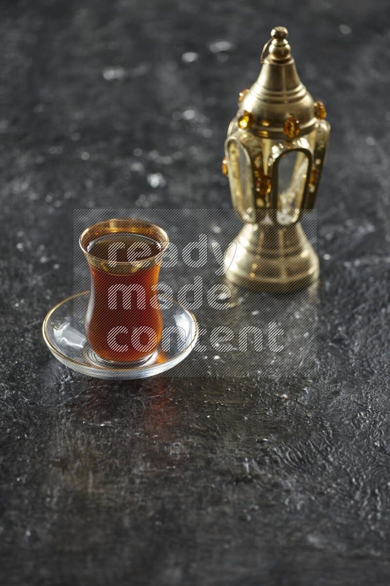 A golden lantern with different drinks, dates, nuts, prayer beads and quran on textured black background