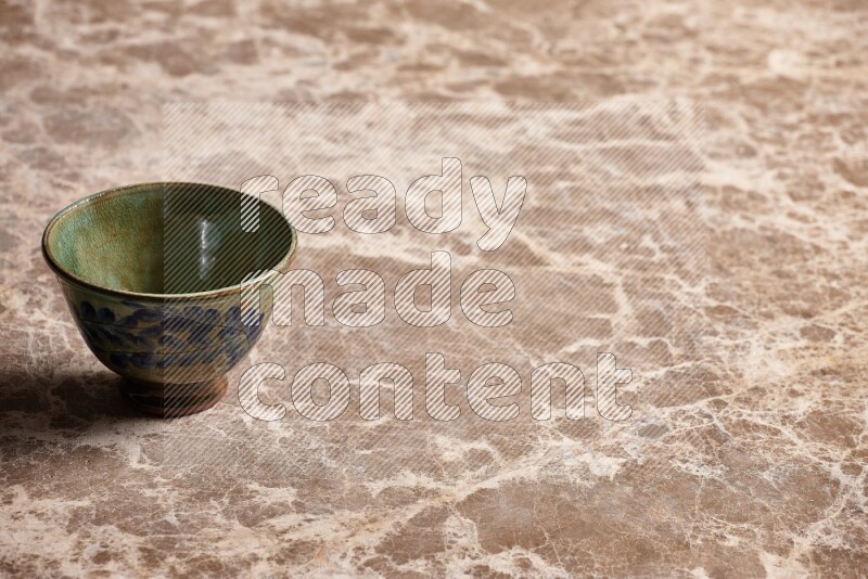 A decorative pottery bowl on beige marble background