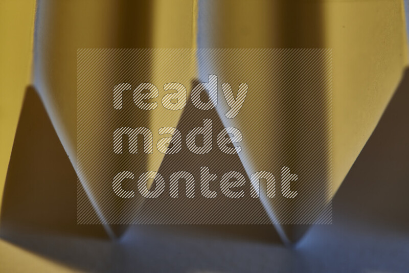 A close-up abstract image showing sharp geometric paper folds in blue gradients and warm tones