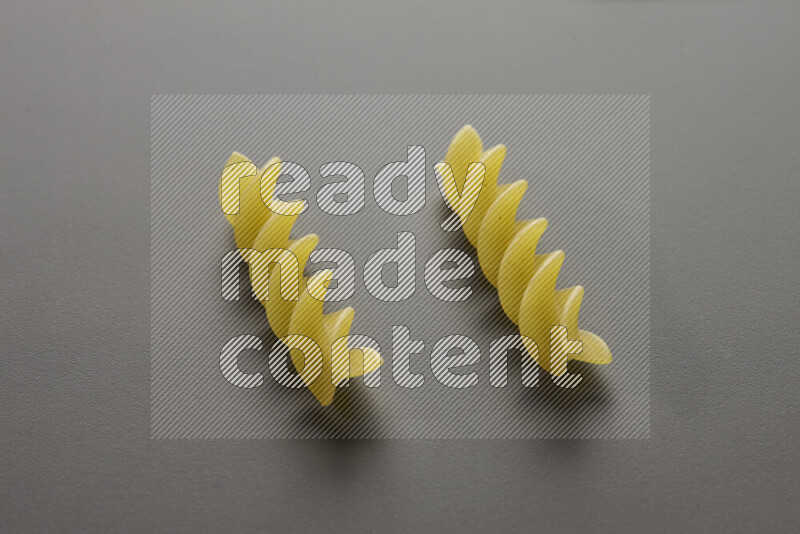Fusilli pasta on grey background