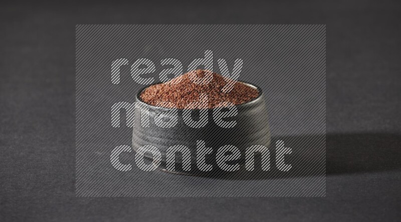 وعاء فخاري أسود ممتلئ ببذور حب الرشاد على أرضية سوداء