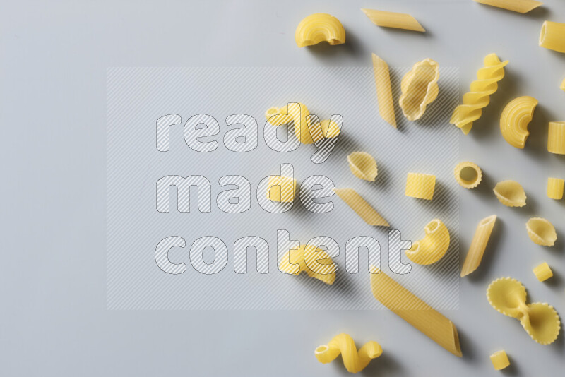 Different pasta types on light blue background