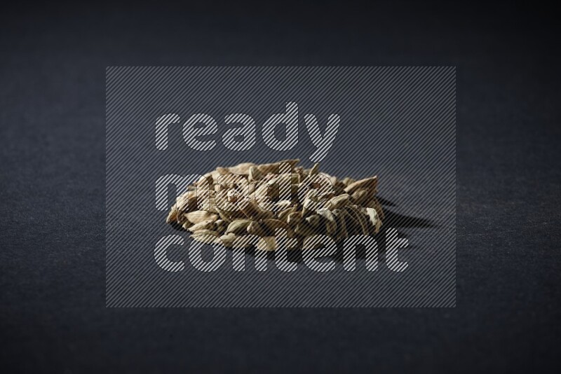 Cardamom in a circle shape on black flooring