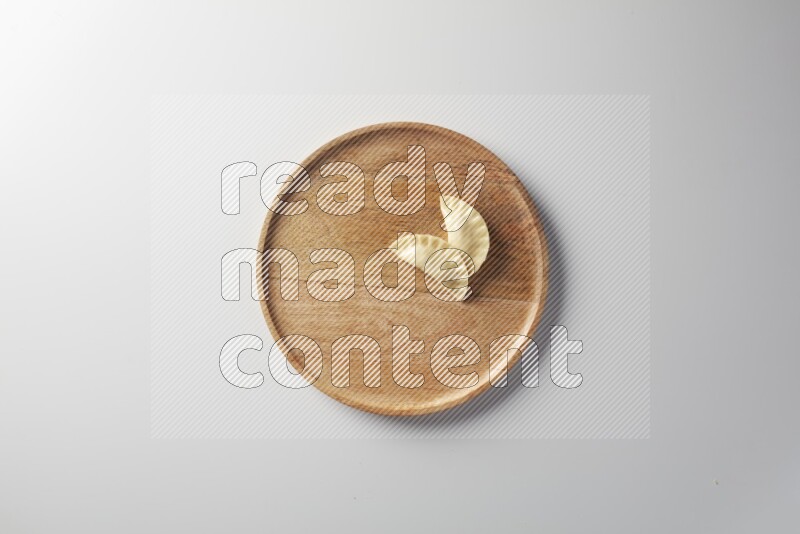 Two Sambosas on a wooden round plate on a white background
