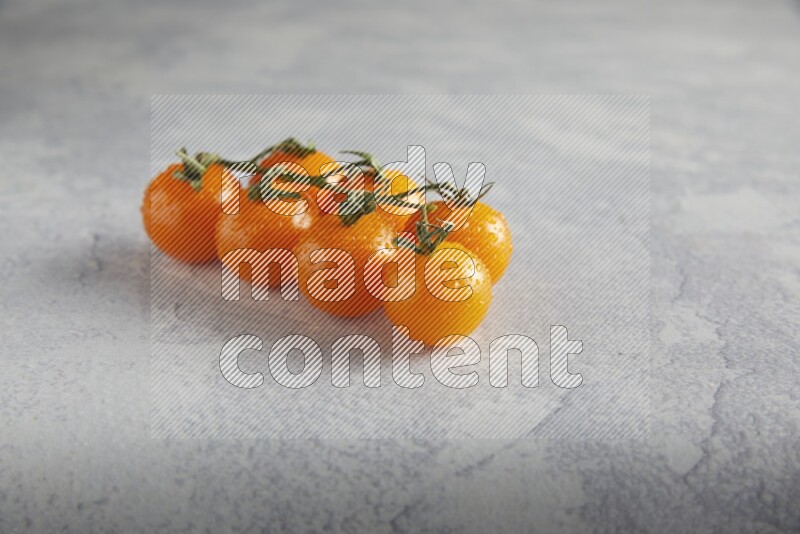 Orange cherry tomato vein on a light grey textured background 45 degree