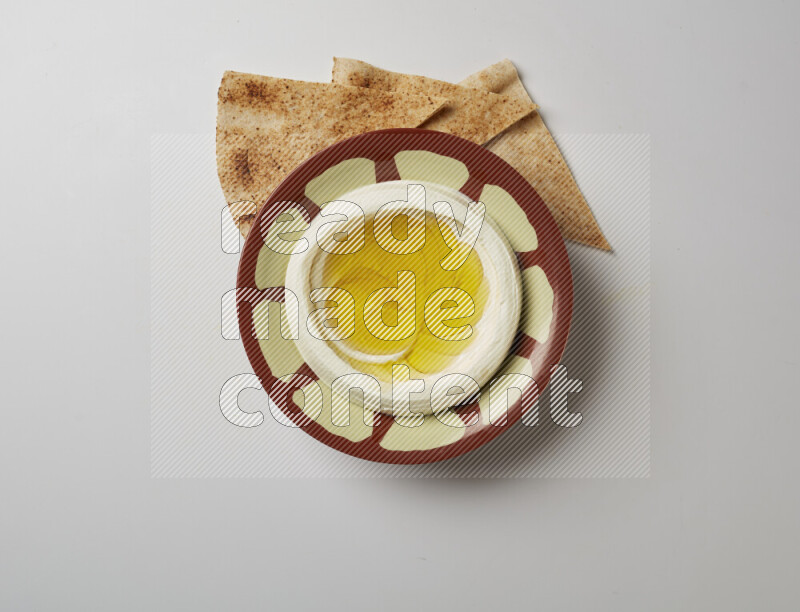 Lebnah garnished with olive oil in a traditional plate on a white background
