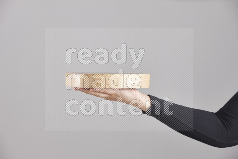 A woman in black abaya holding different wooden essentials in different positions