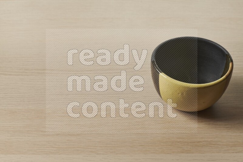 A multicolored pottery bowl on light wooden background
